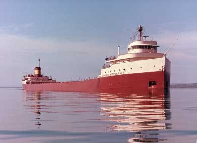 A large red ship underway in calm conditions.