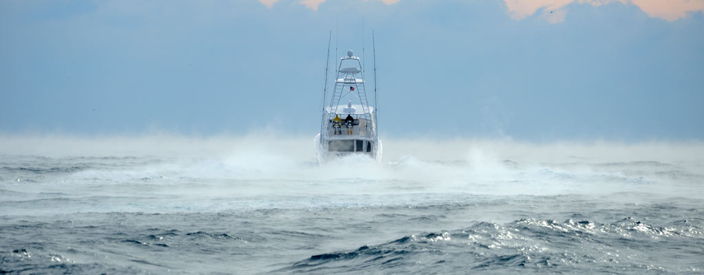 a boat in the distance on misty, cold water