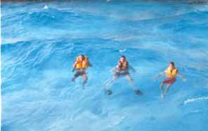 3 test subjects in the wave pool get to experience how the inflatable pfd's perform in rough water.