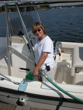A young lady fills the fuel tank on her center console boat.
