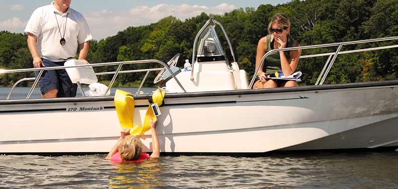 a child uses a ladder to climb aboard a boat