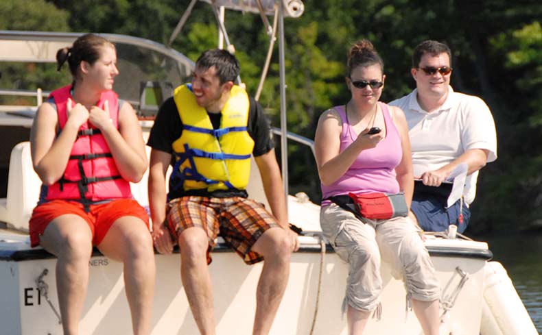 four people sit on a boat