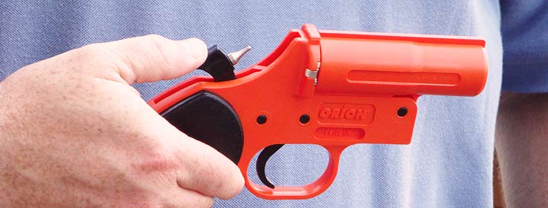 a man holding an orange flare gun