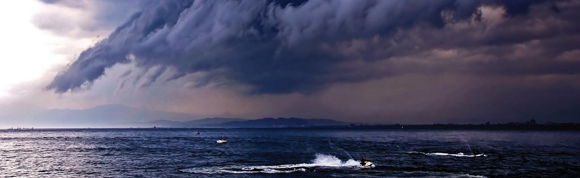 a storm approaching some people on jetskis