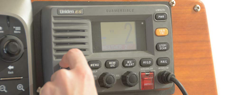 a woman turns a nob on a VHF radio