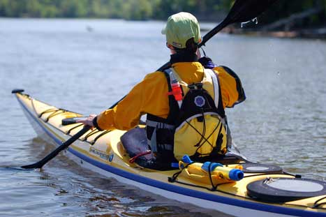 a woman paddles a kayak