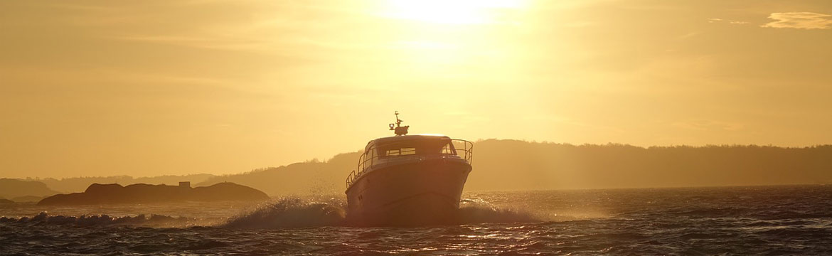 a yacht powering in the sea at sunset