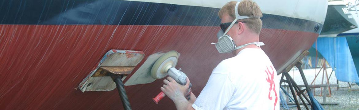 a man sands the hull of a boat